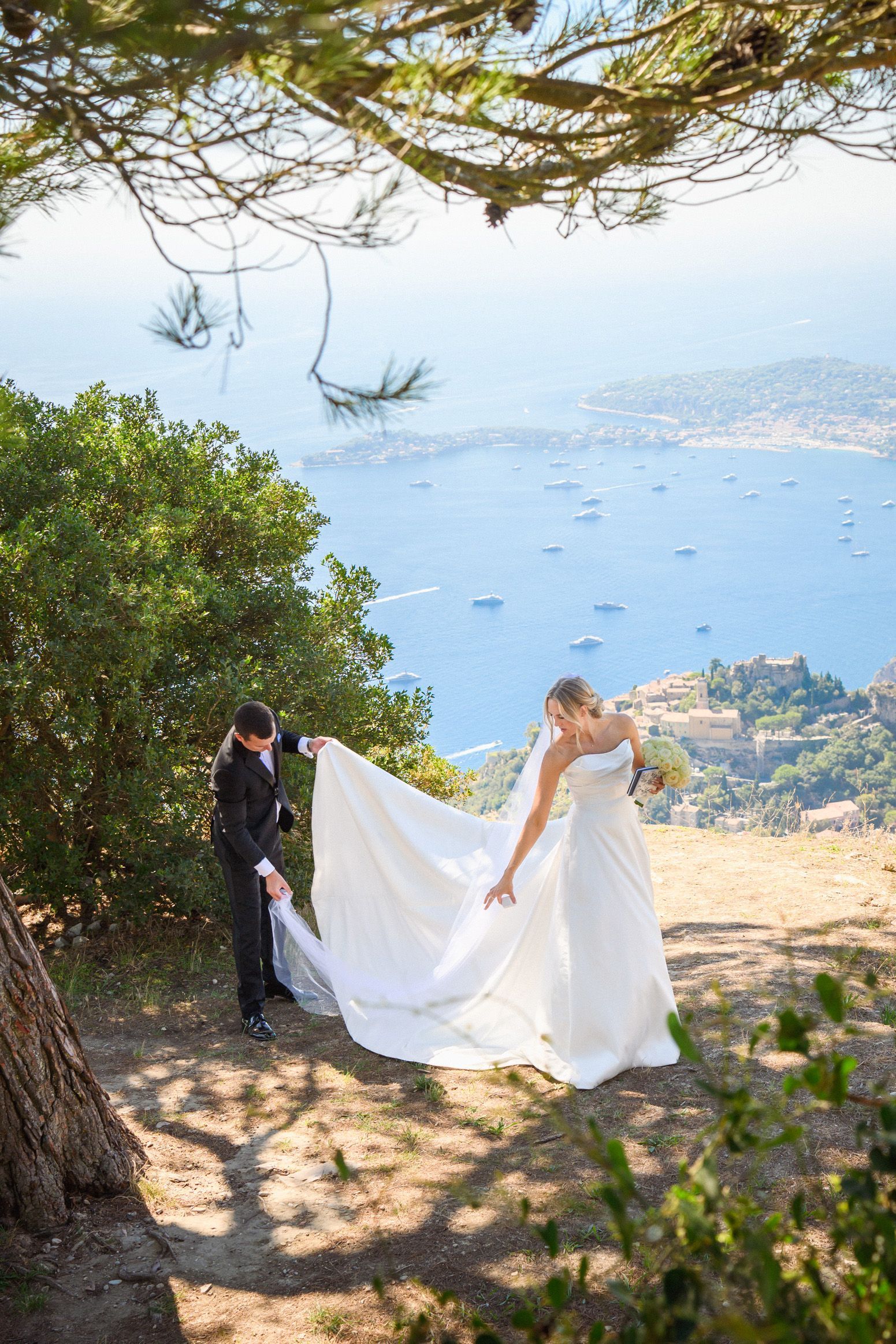 Couple in wedding attire near Eze prepare for an elopement ceremony with spectacular view over French Riviera.