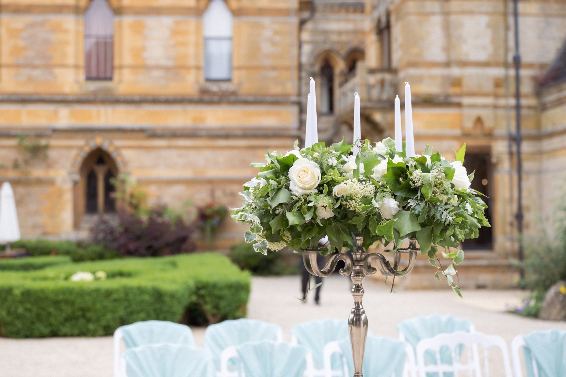 A flower stand of white and cream flowers at a luxury wedding ceremony