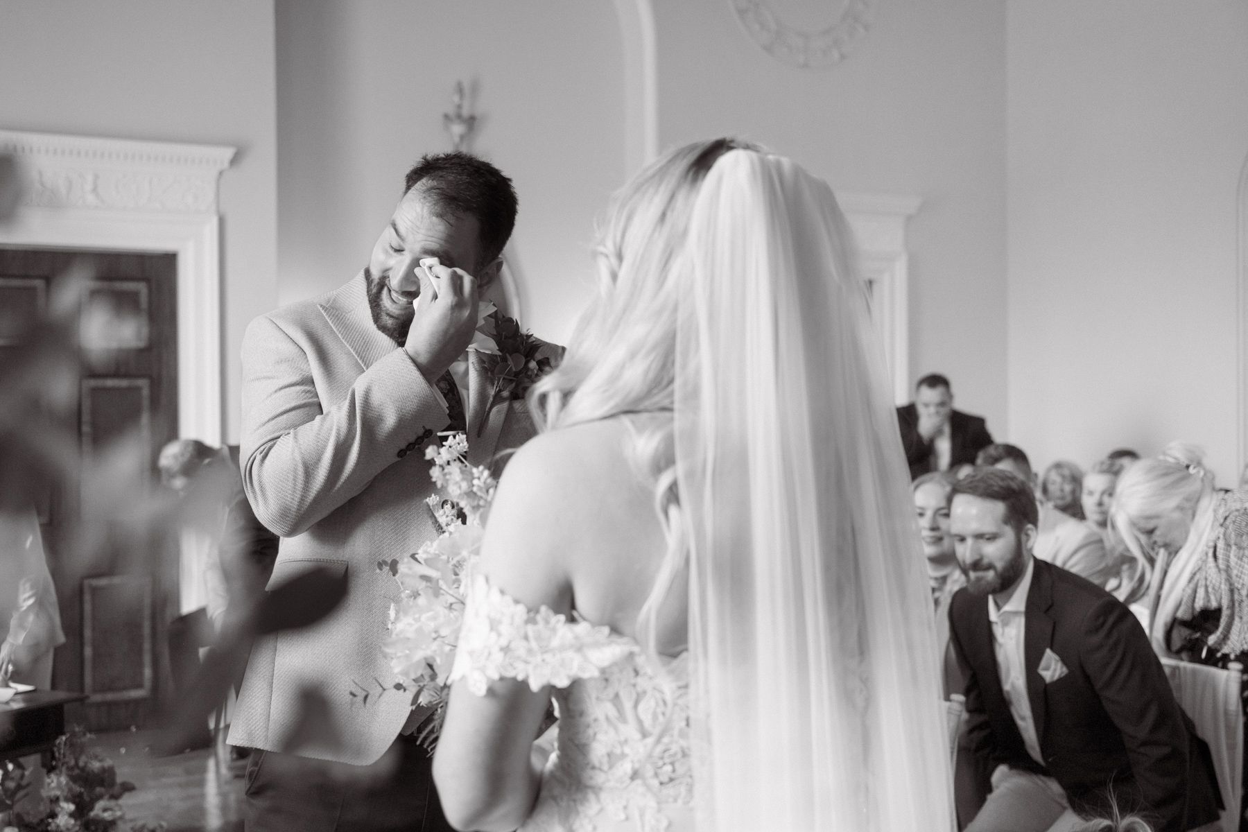 The groom wipes away a tear after seeing the bride during the ceremony.