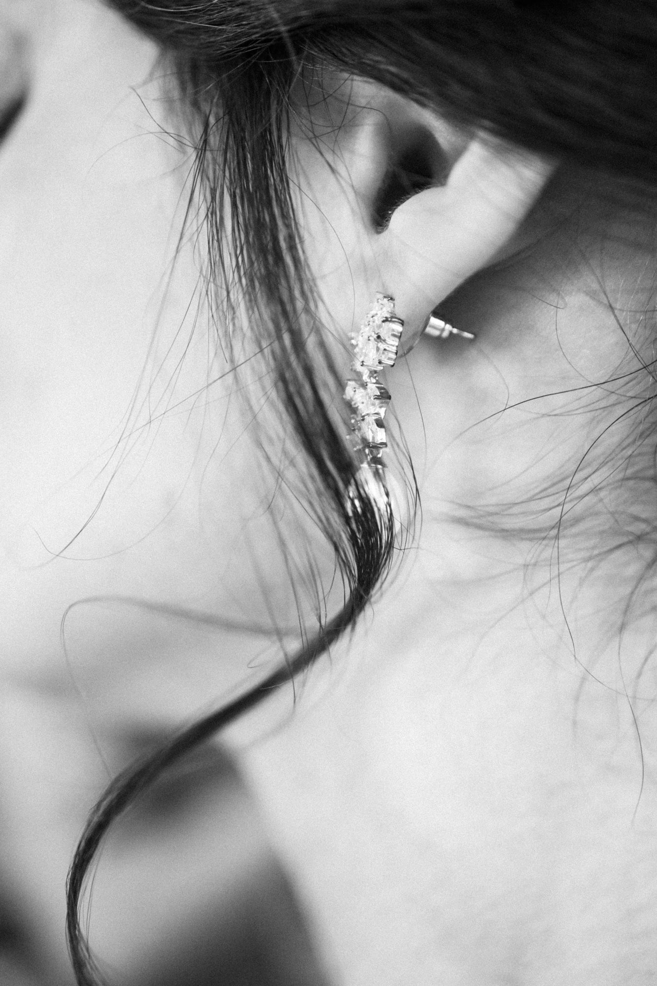 Les boucles d'oreilles de la mariée reposent sous ses cheveux le jour de son mariage.