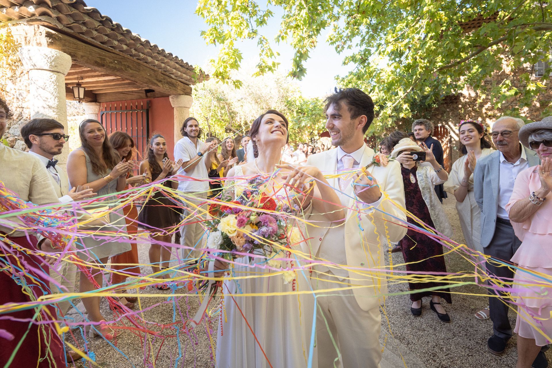 Le couple traverse des banderoles colorées au lieu de confettis au Château Font du Broc.