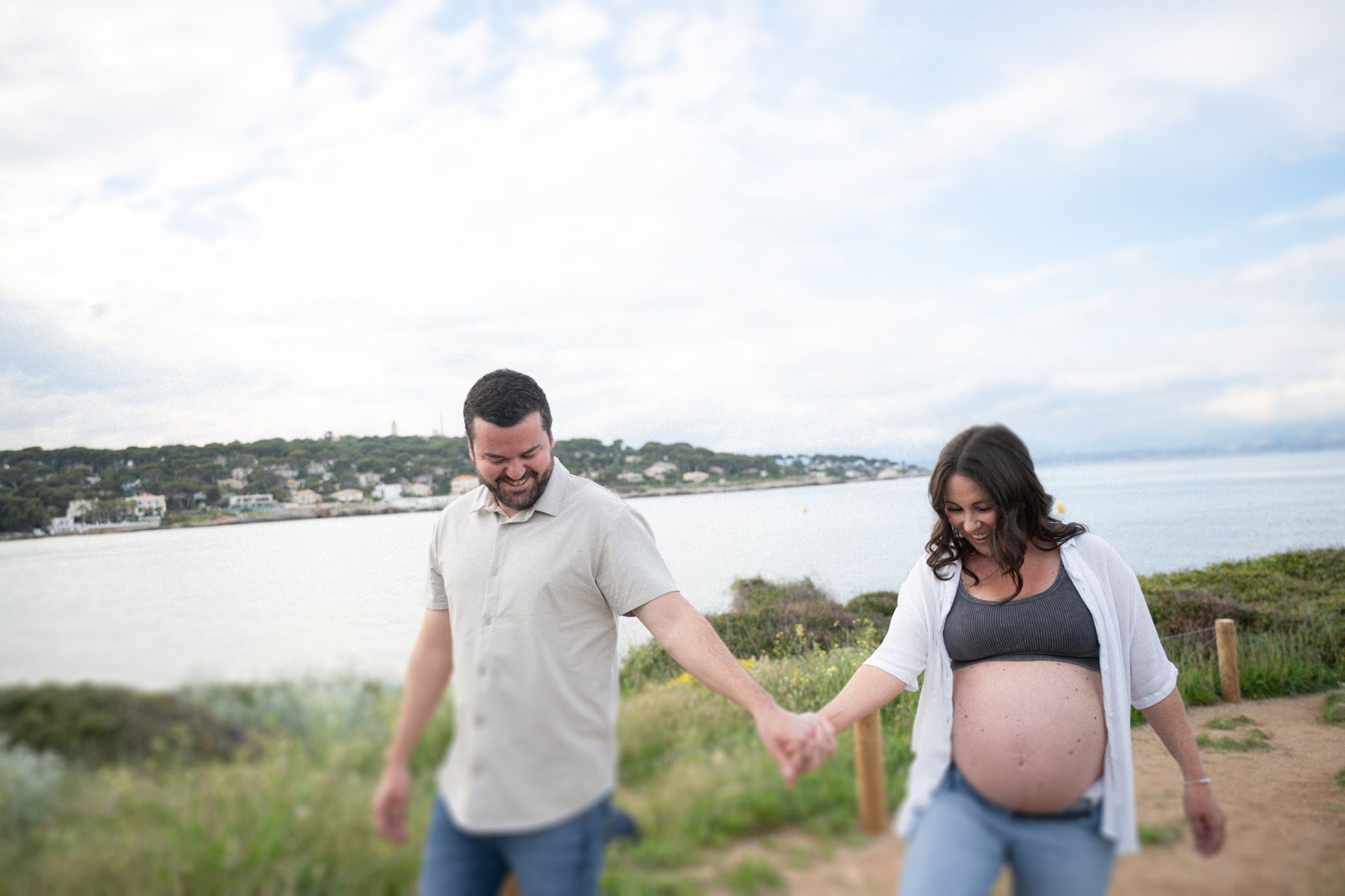 A couple walk hand in hand during a spontaneous maternity photoshoot
