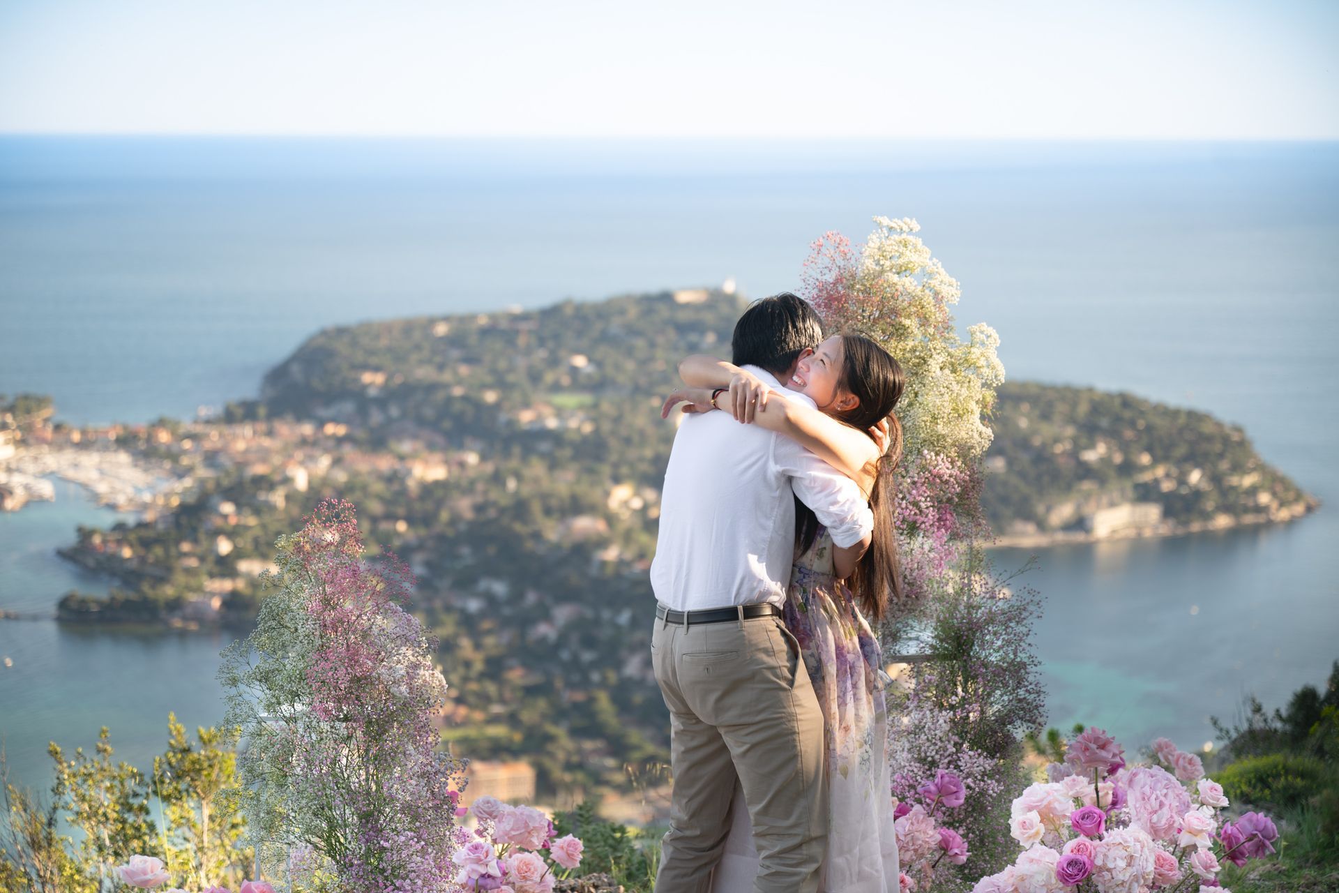 A couple hug after getting engaged after a surprise proposal.