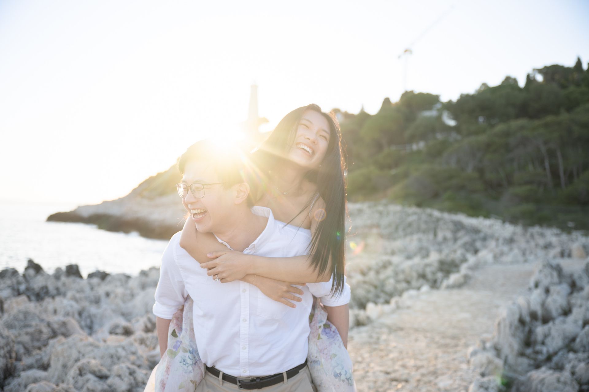 A professional portrait of a young couple laughing during a romantic photoshoot.