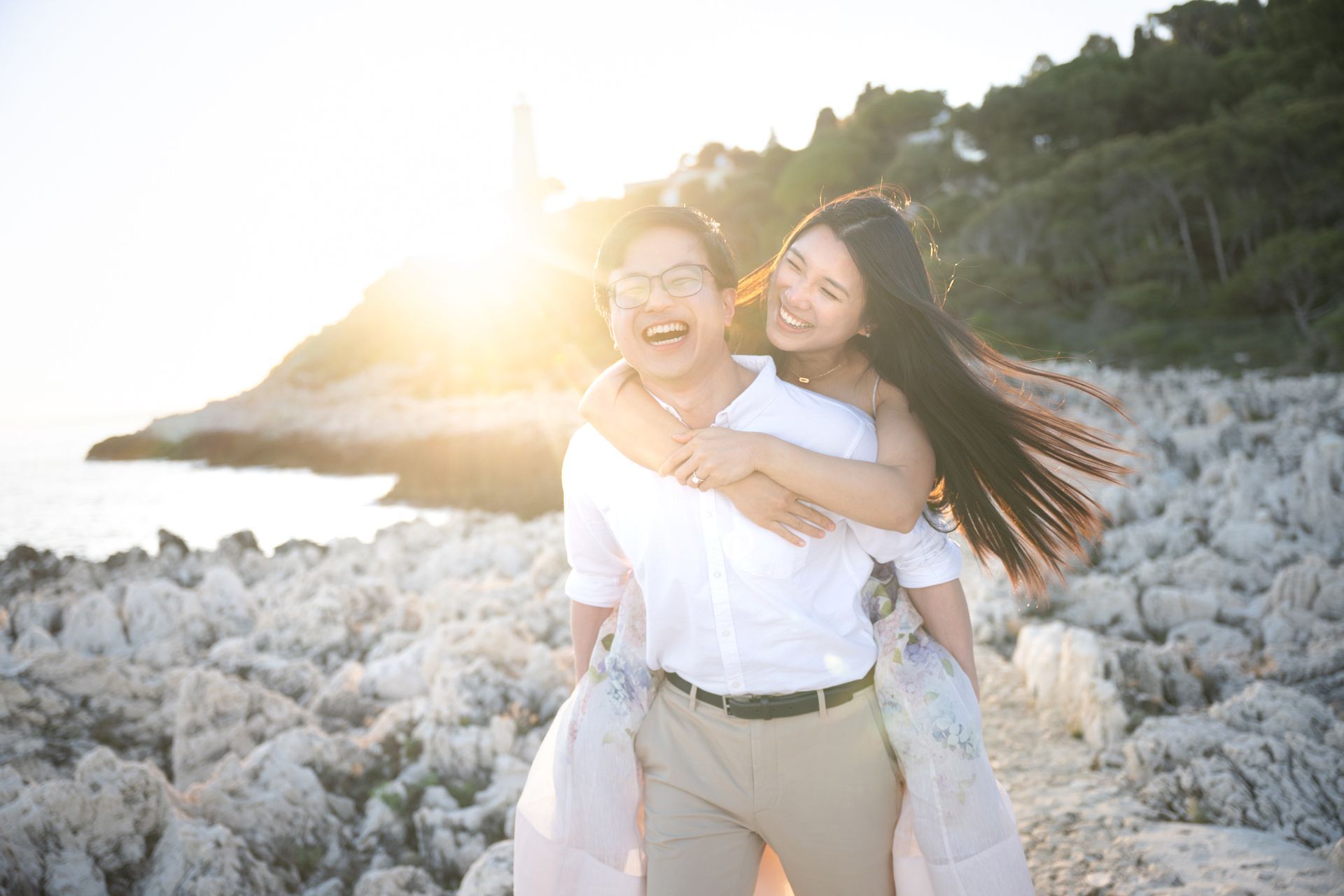 A professional photograph of a young couple during a romantic photoshoot at sunset on the French Riviera.