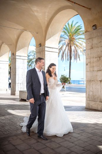 Natural, relaxed wedding photography of a bride and groom walking near the Promenade des Anglais in Nice, France.