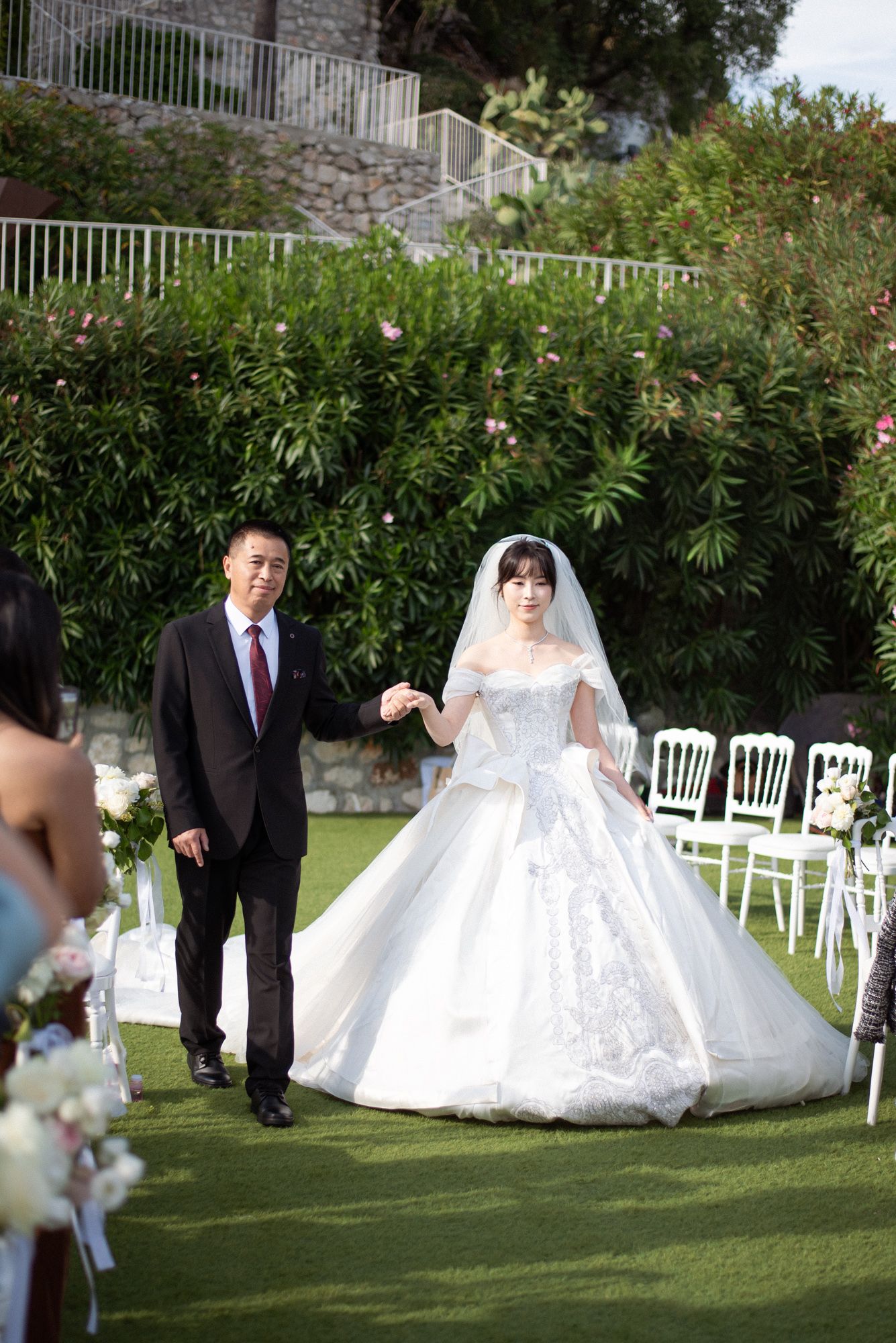 The bride walking with her father during a ceremony at the Chevre d'Or Hotel