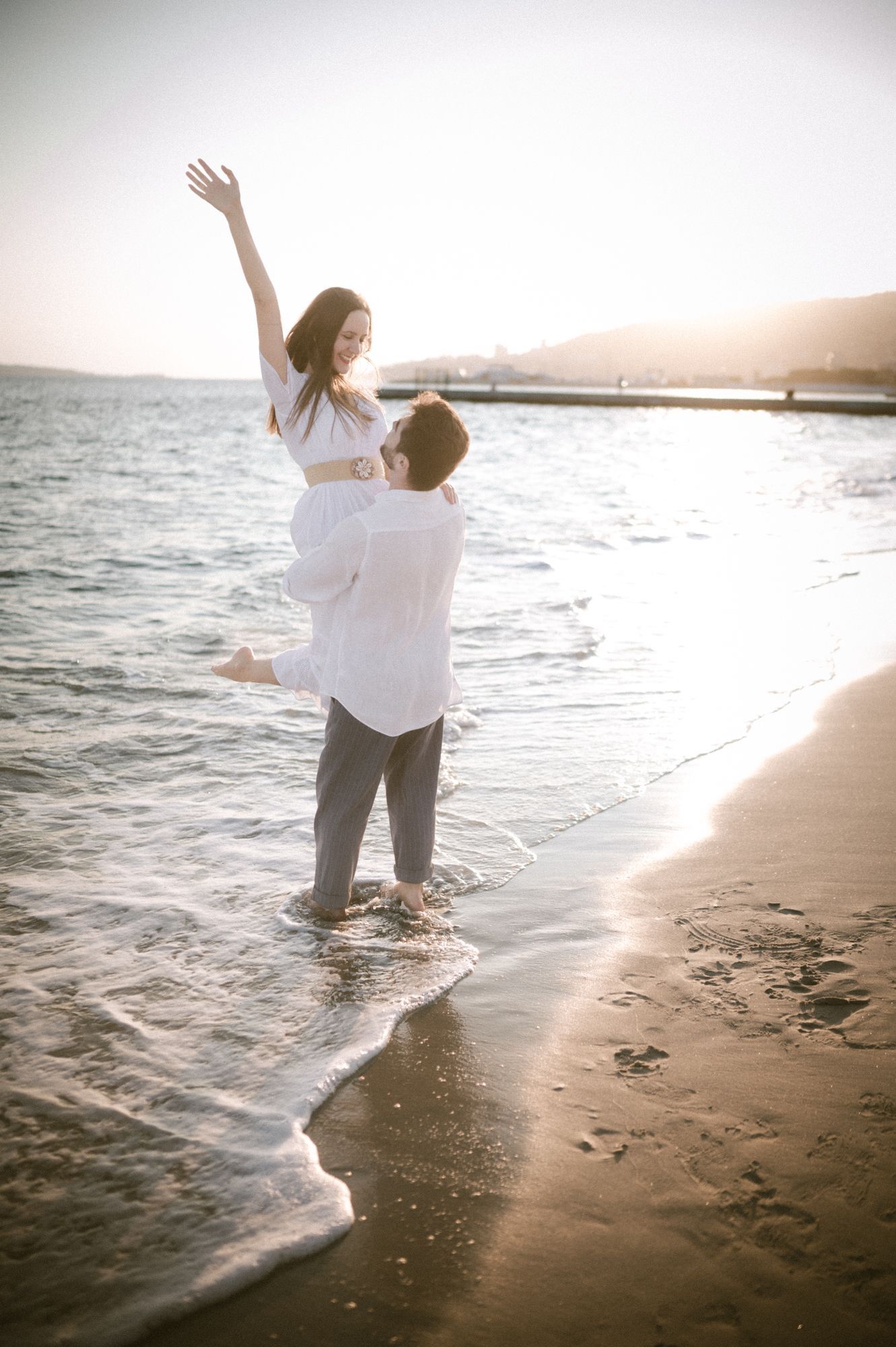 A couple on a back-lit beach on the French Riviera during a romantic photoshoot