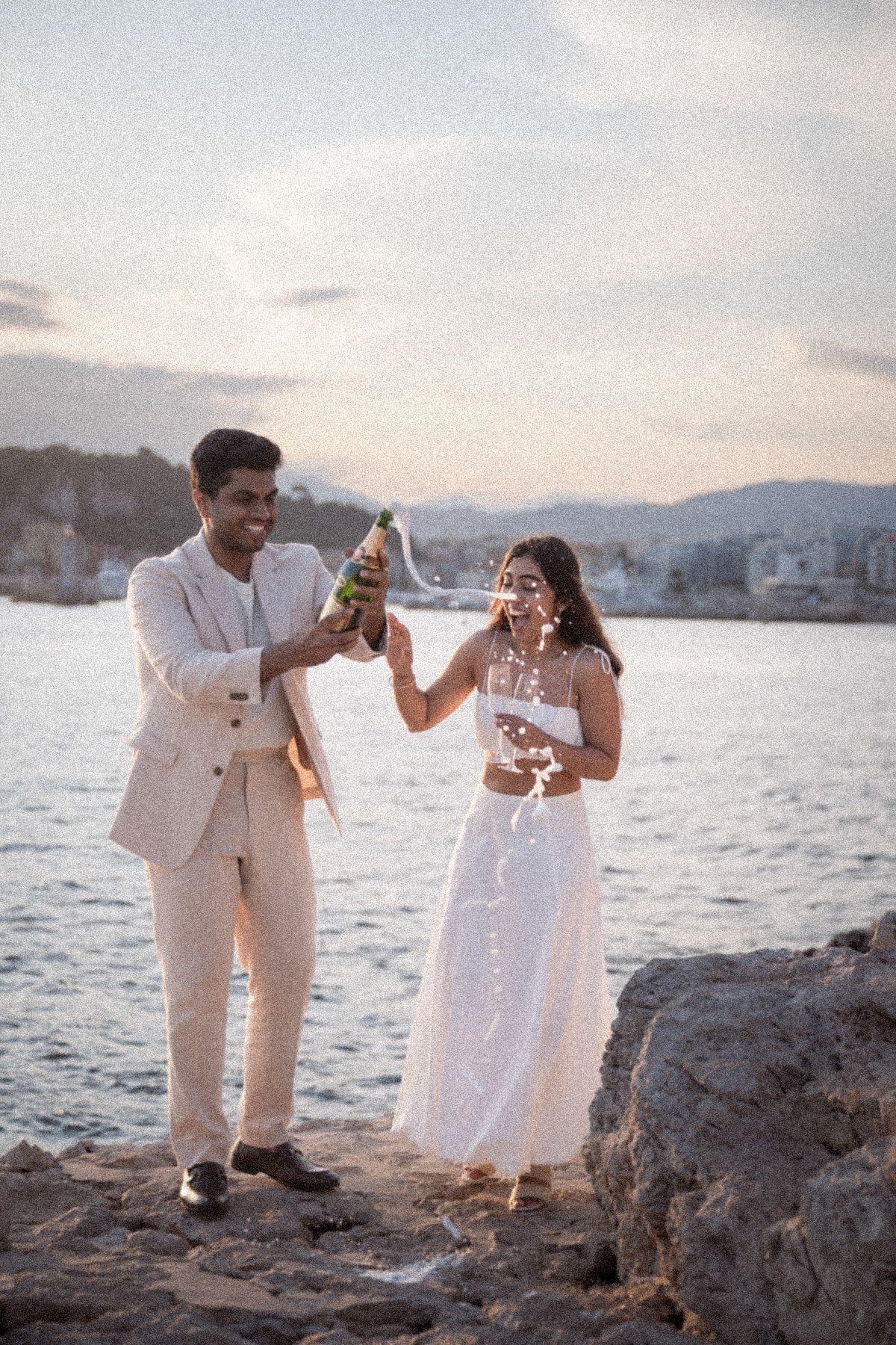 The opening of champagne after an idealistic surprise proposal at golden hour.