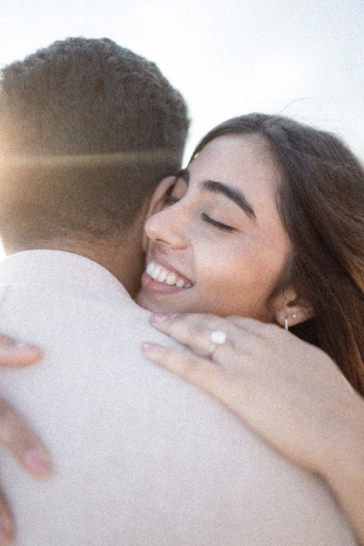 A couple hug after getting engaged.