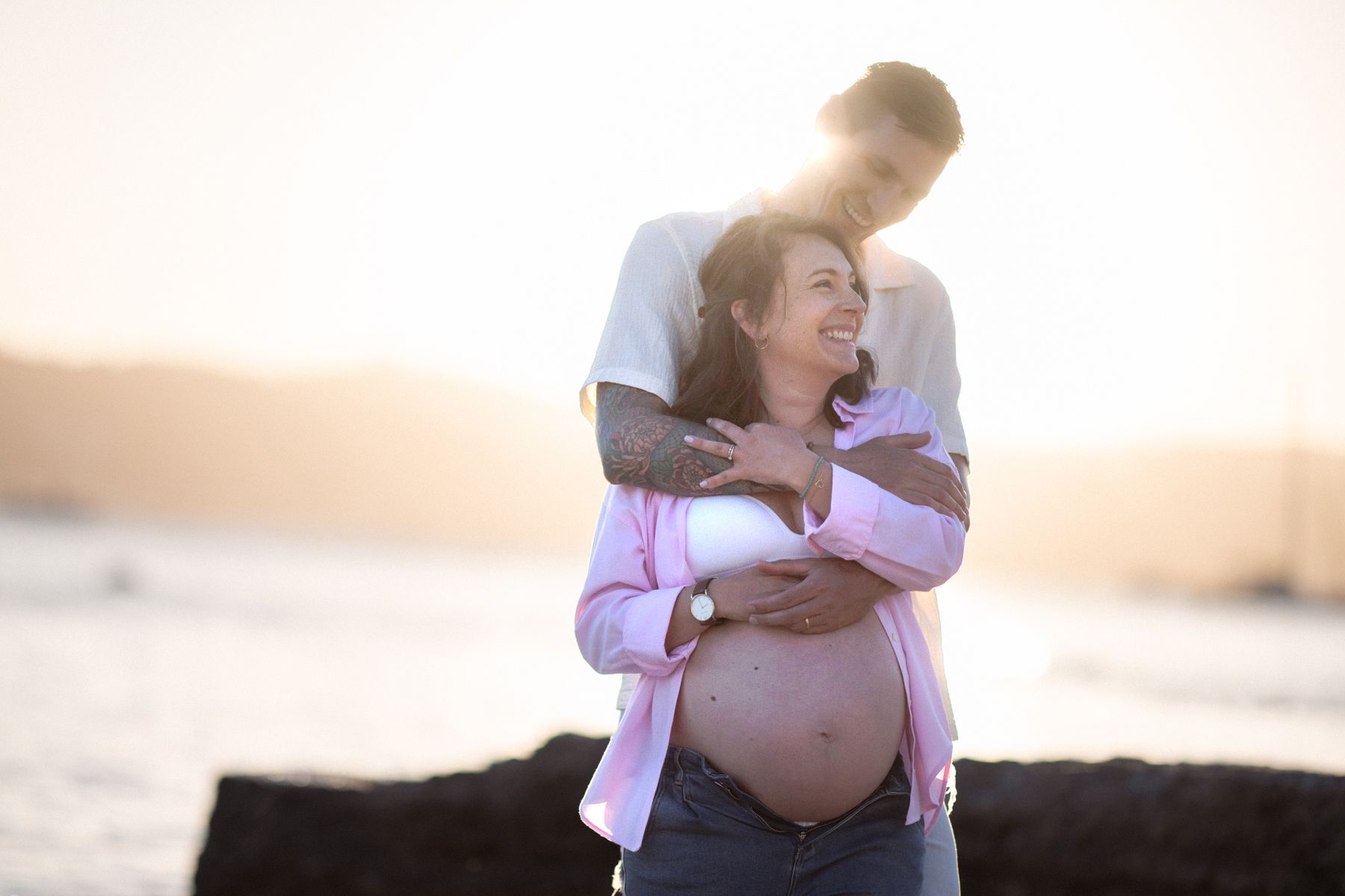 A maternity photoshoot showing a couple hugging at golden hour on the French Riviera.