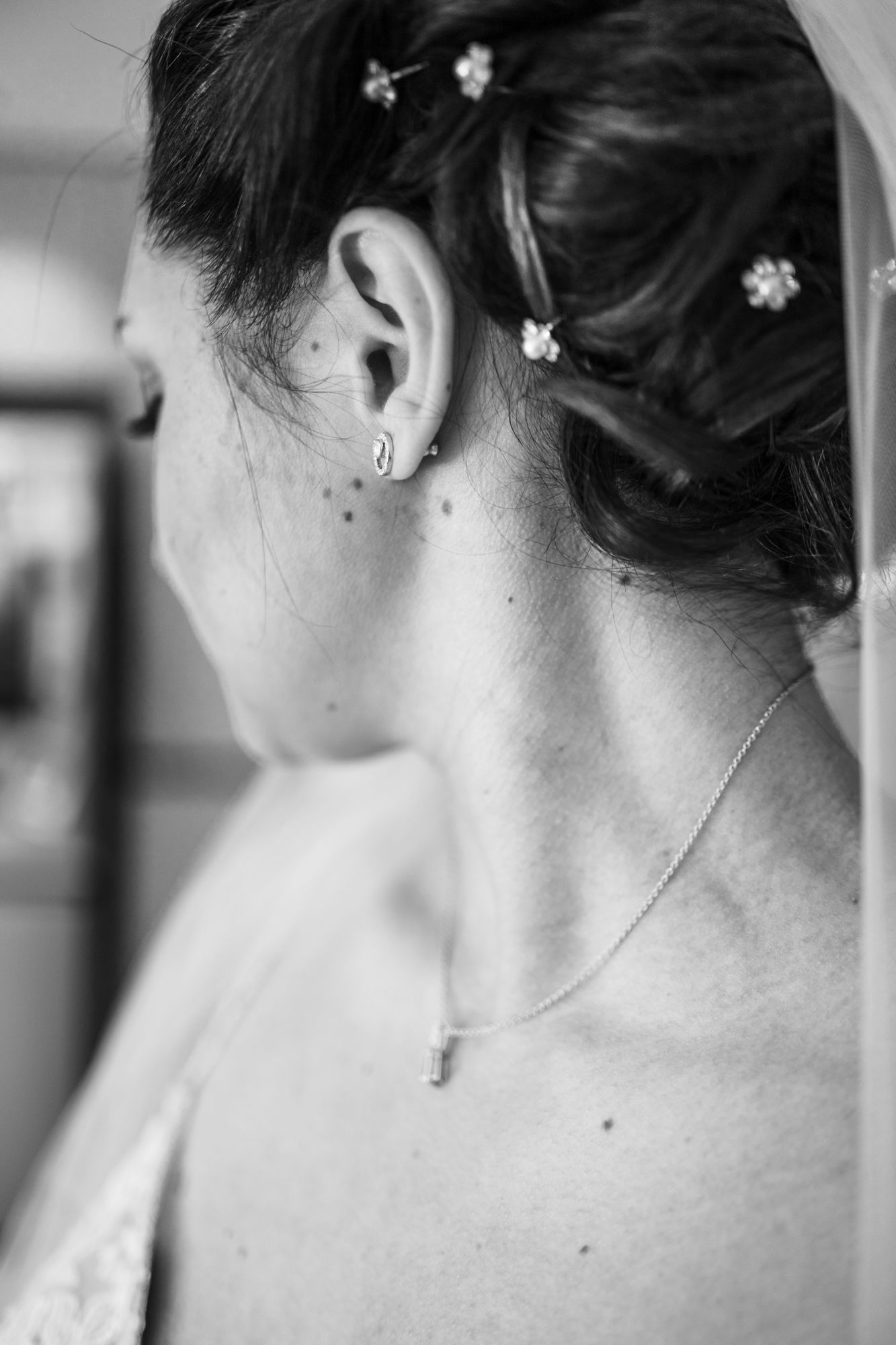 un élégant portrait de mariée en noir et blanc montrant un voile et des boucles d'oreilles