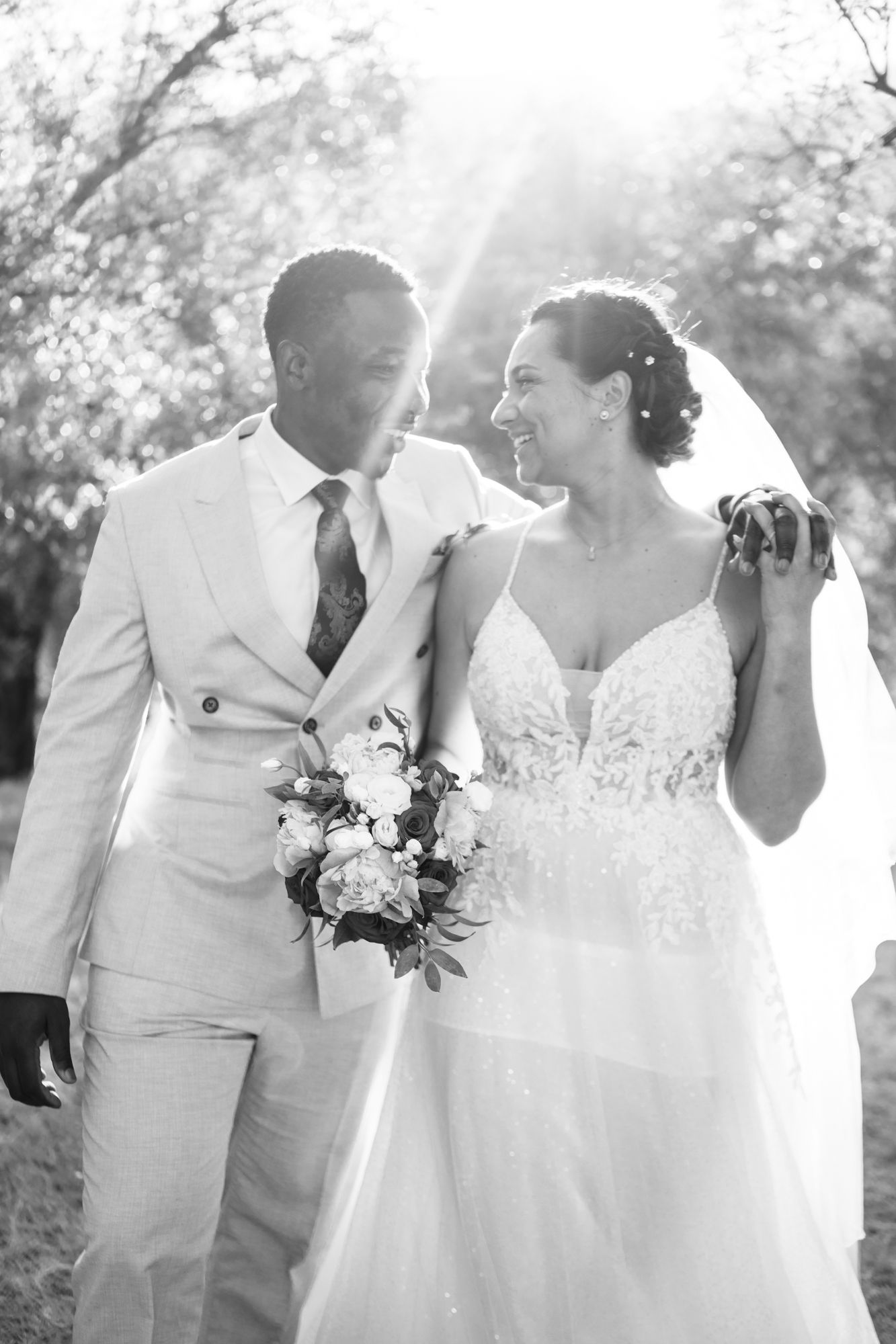 une séance de photos de mariage détendue, naturelle et amusante dans une oliveraie. Le couple marche et rit