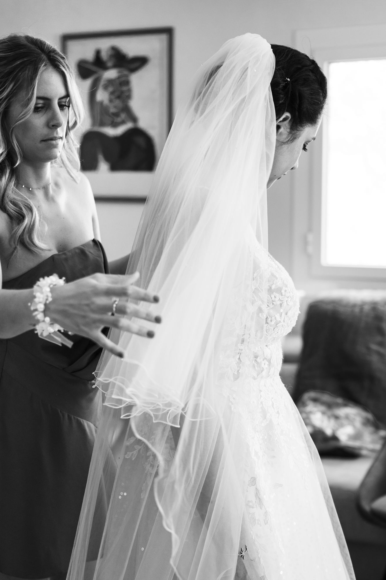 un élégant portrait nuptial en noir et blanc montrant le voile de la robe de mariée avant un mariage