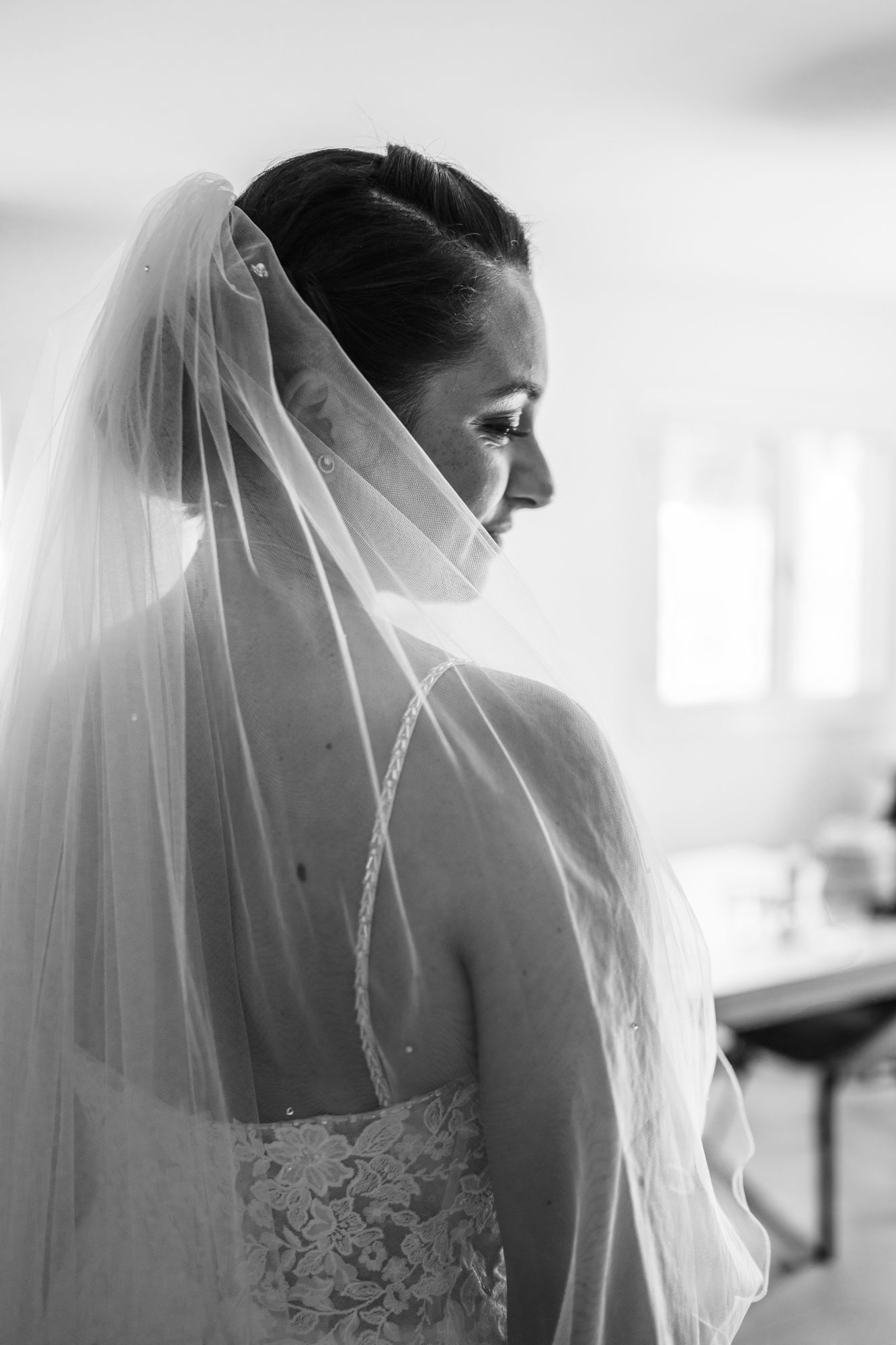 un élégant portrait de mariée en noir et blanc montrant un voile et des boucles d'oreilles