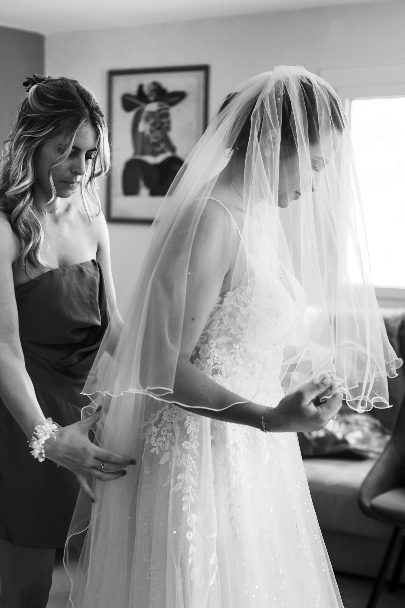 un élégant portrait nuptial en noir et blanc montrant le voile de la robe de mariée avant un mariage