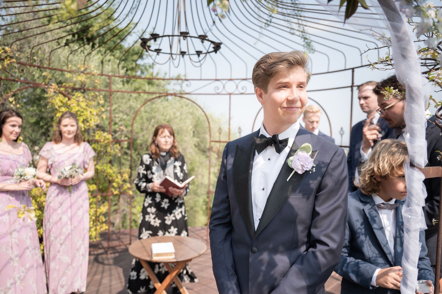 une cérémonie de mariage à la campagne sous une véranda décorée de fleurs et de rubans