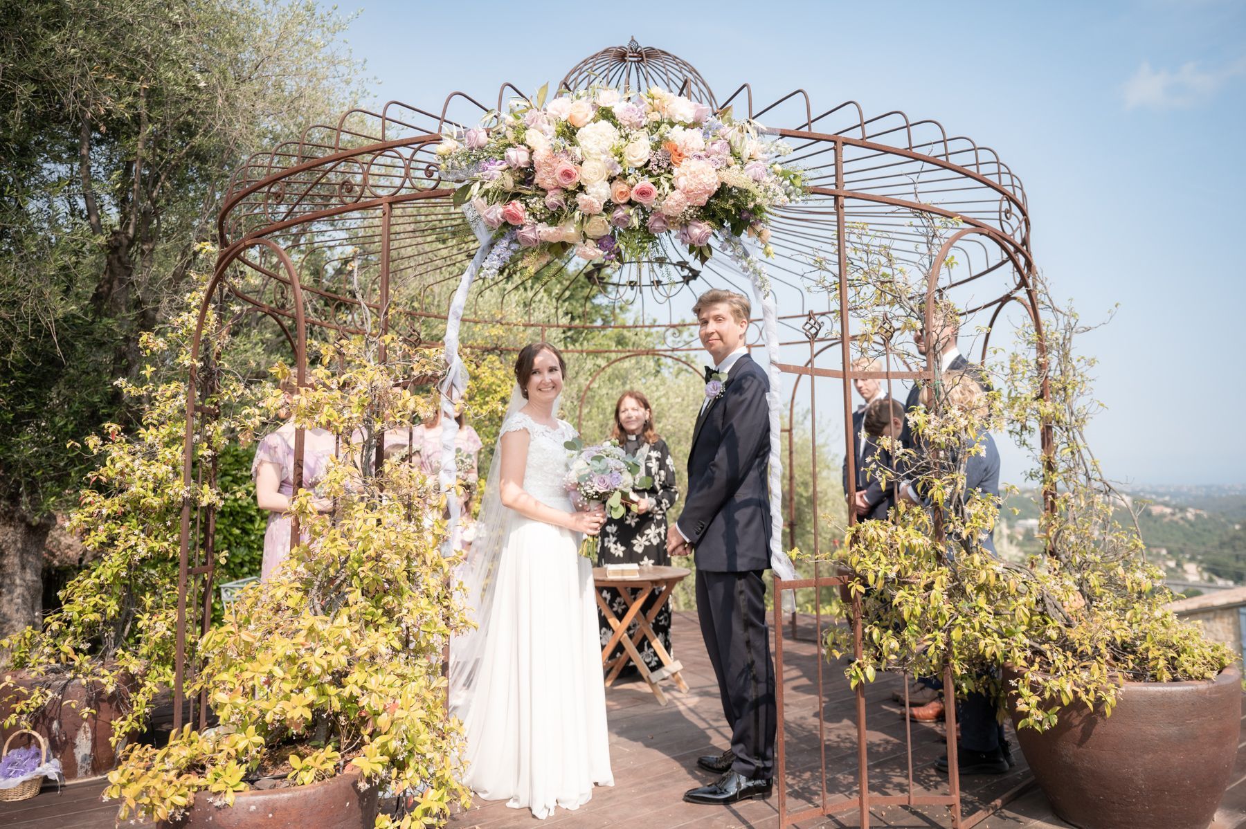 une cérémonie de mariage à la campagne sous une véranda décorée de fleurs et de rubans