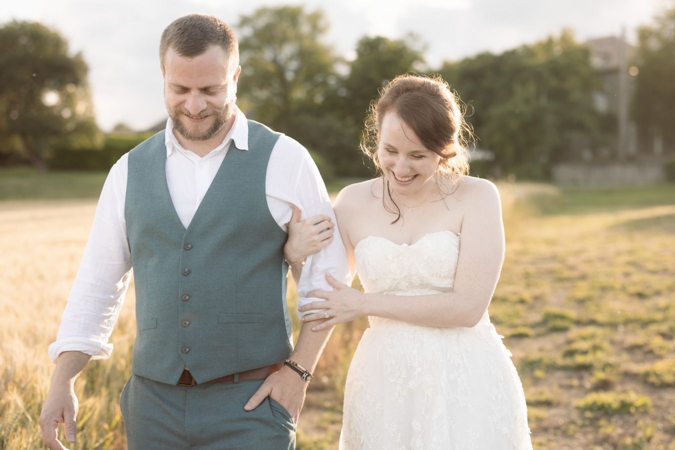 A couple in wedding attire laugh at a wedding in Occitanie, Lot Department, France