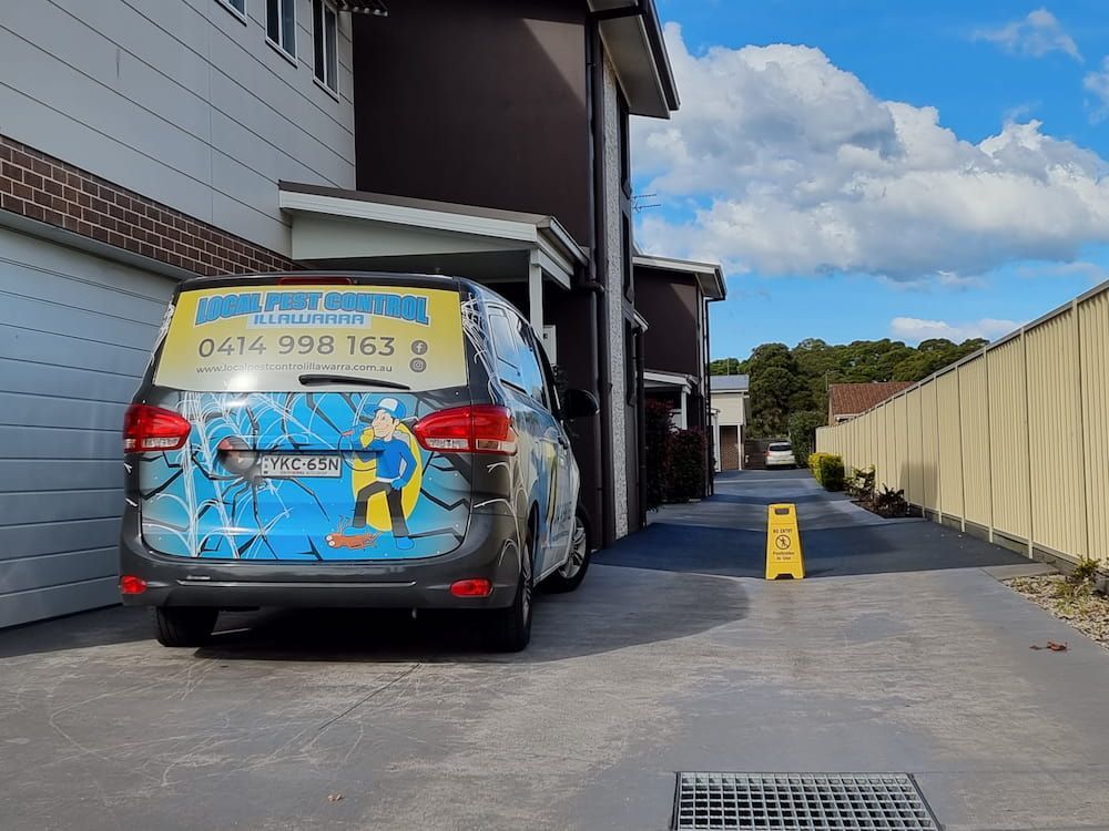 A Blue Van Is Parked In Front Of A Building — Local Pest Control Illawarra in Horsley, NSW