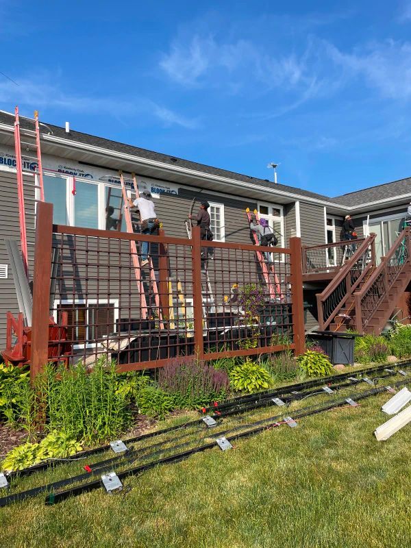 A group of people are working on the side of a house.