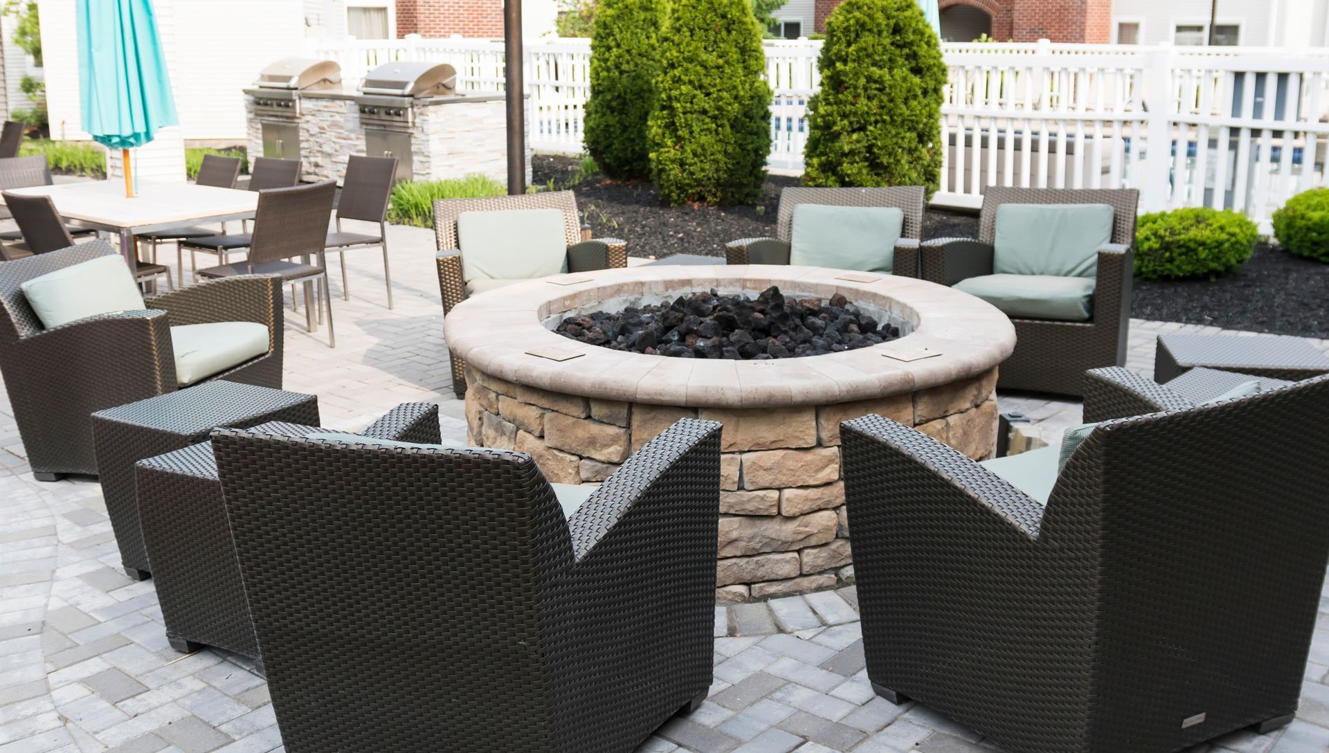 Fire Pit Surrounded by Chairs and Tables on a Patio