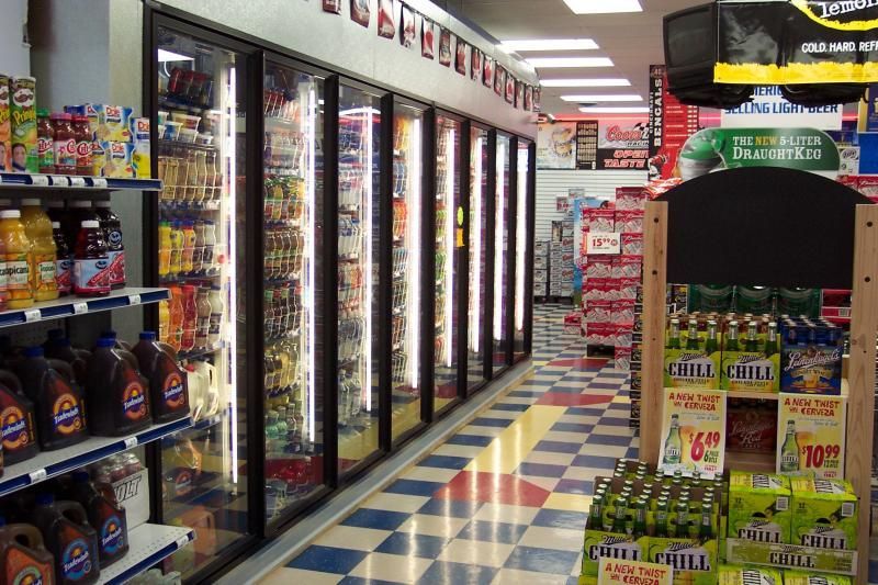 The inside of a grocery store with a display of coca cola