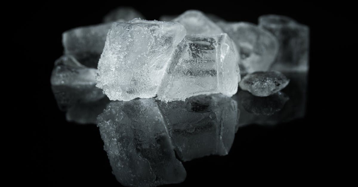 A black and white photo of ice cubes on a black surface.
