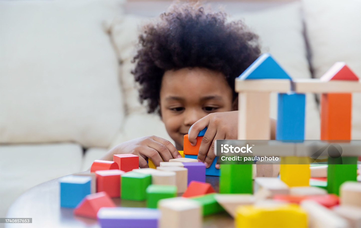 Young child is playing with colorful wooden blocks on a table.