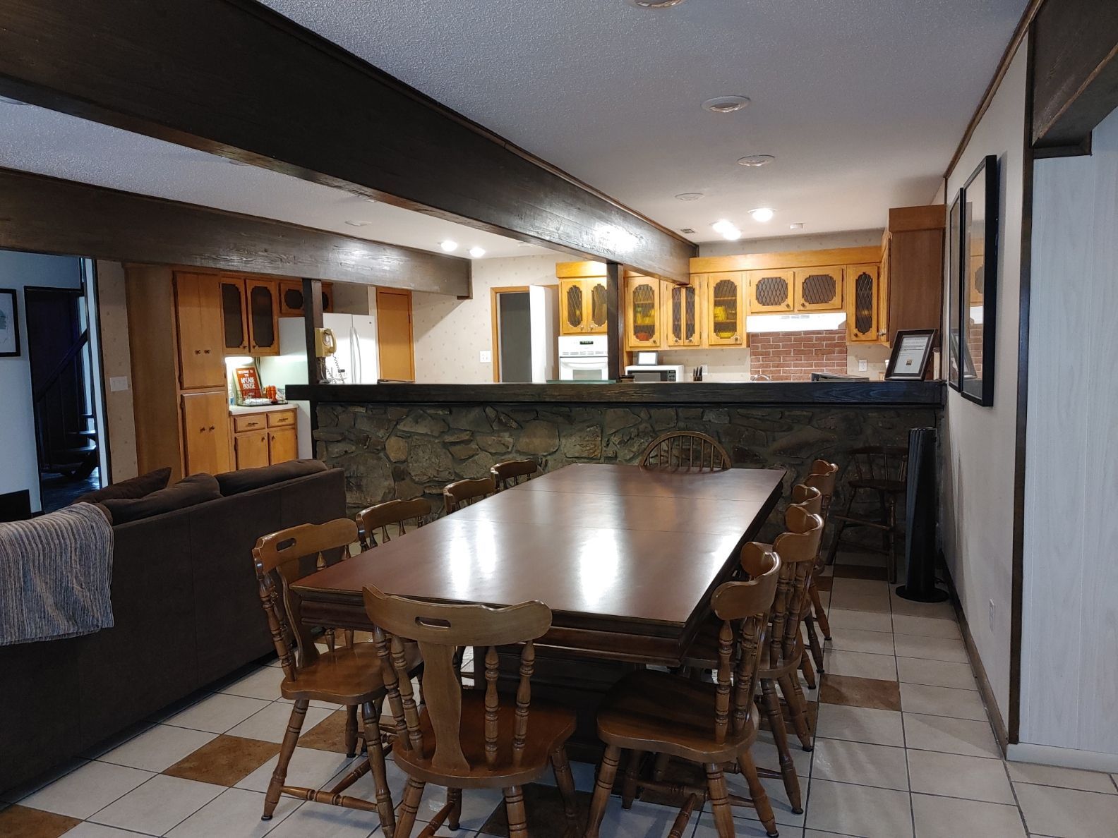 Dining room with wooden table and chairs in a rustic, open kitchen interior