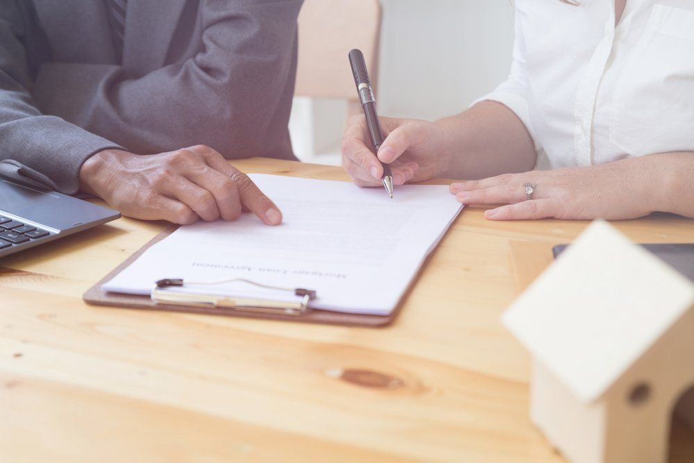 Woman Writing on Agreement Paper — Mortgage Brokers In Mundingburra, QLD