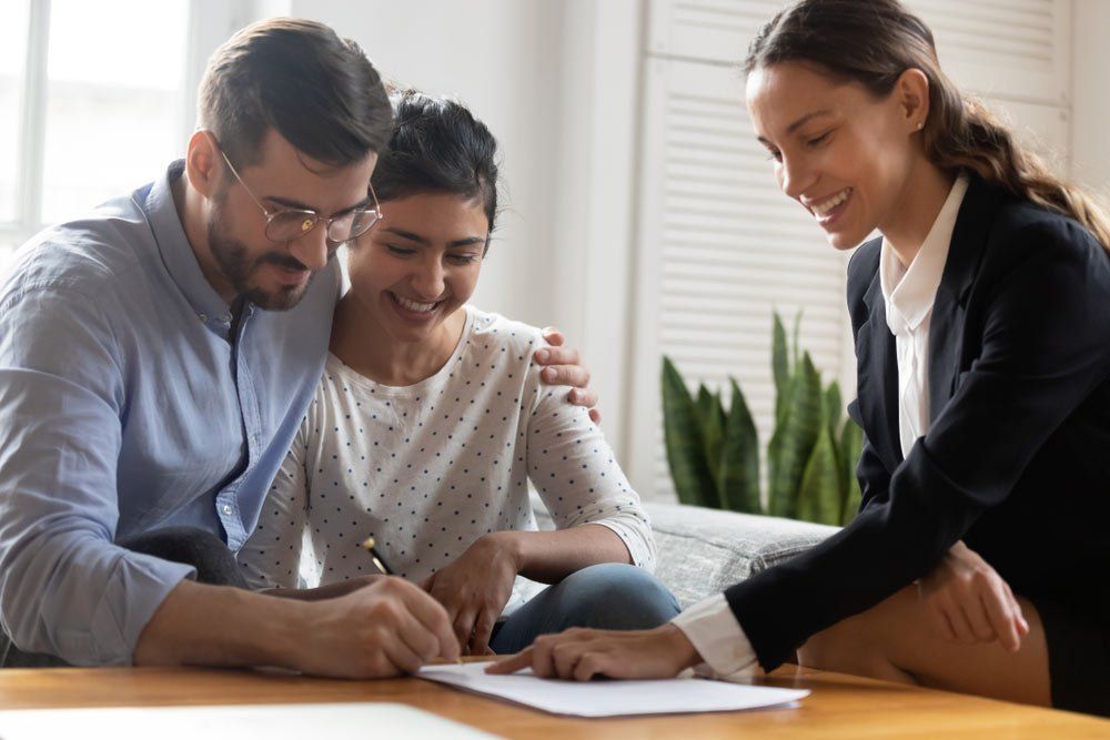 Happy Married Couple Signing A Contract — Mortgage Brokers In Mundingburra, QLD