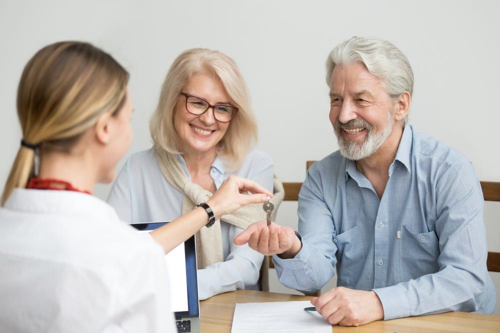 Realtor Handing Keys To A Couple — Mortgage Brokers In Mundingburra, QLD