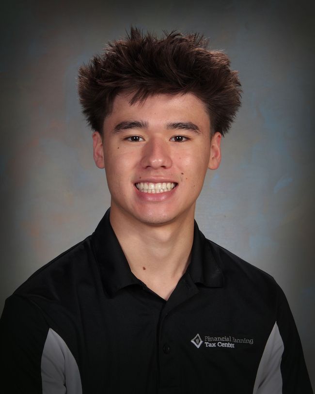 Portrait of a smiling person in a black collared shirt against a gray studio backdrop
