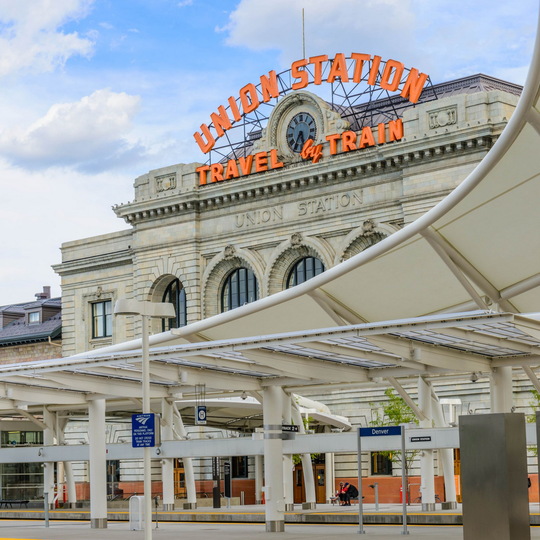 Union Station facade with orange sign and white canopy under a partly cloudy sky