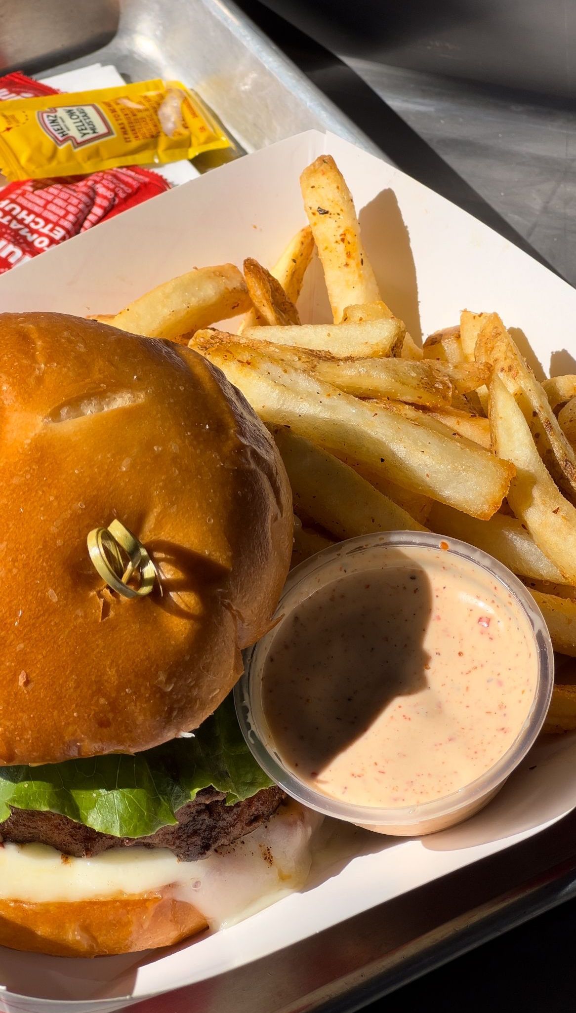 a hamburger and french fries are on a paper plate .