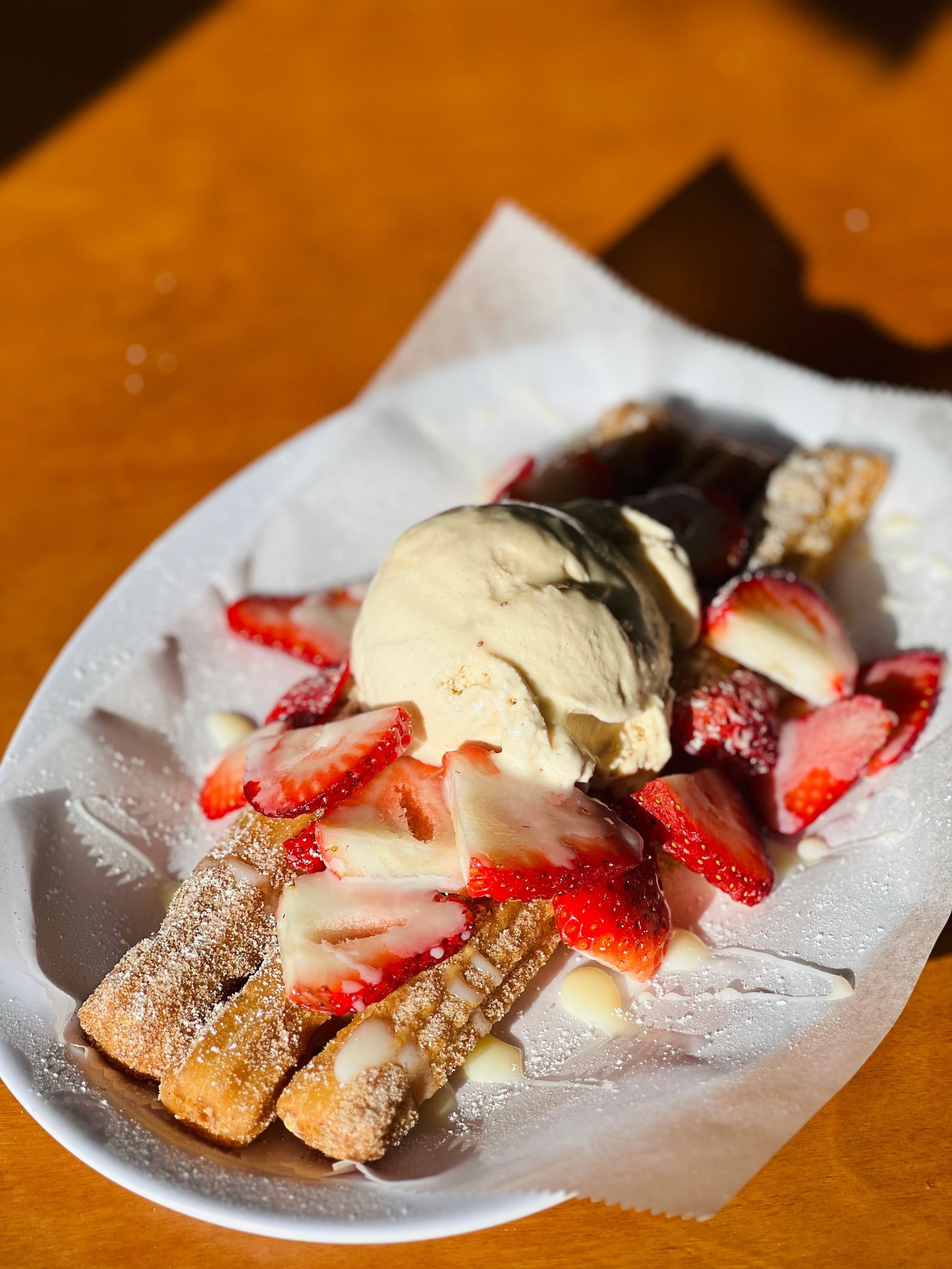 churros with strawberries and ice cream on a plate