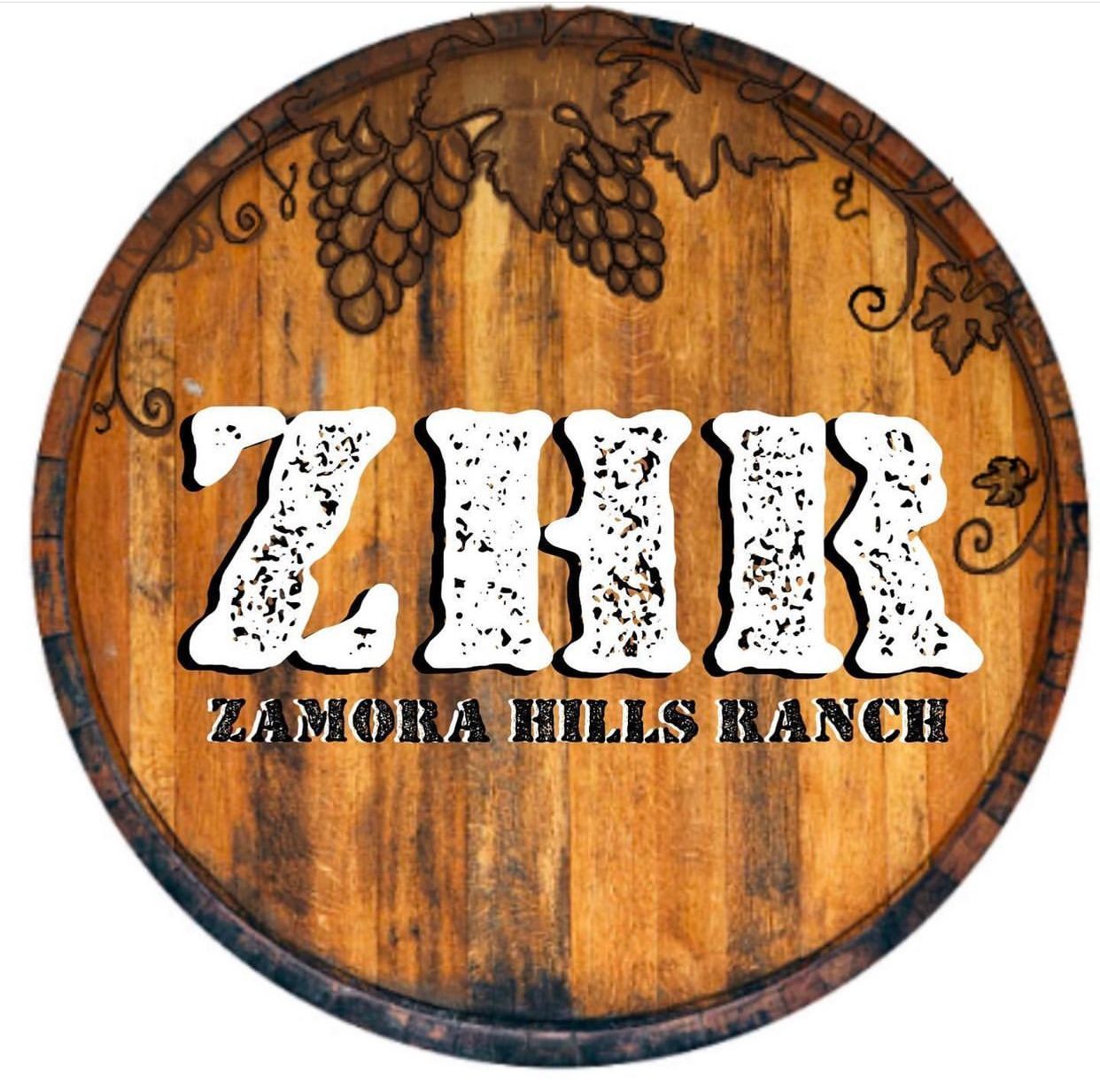 a logo for zamora hills ranch is on a wooden barrel