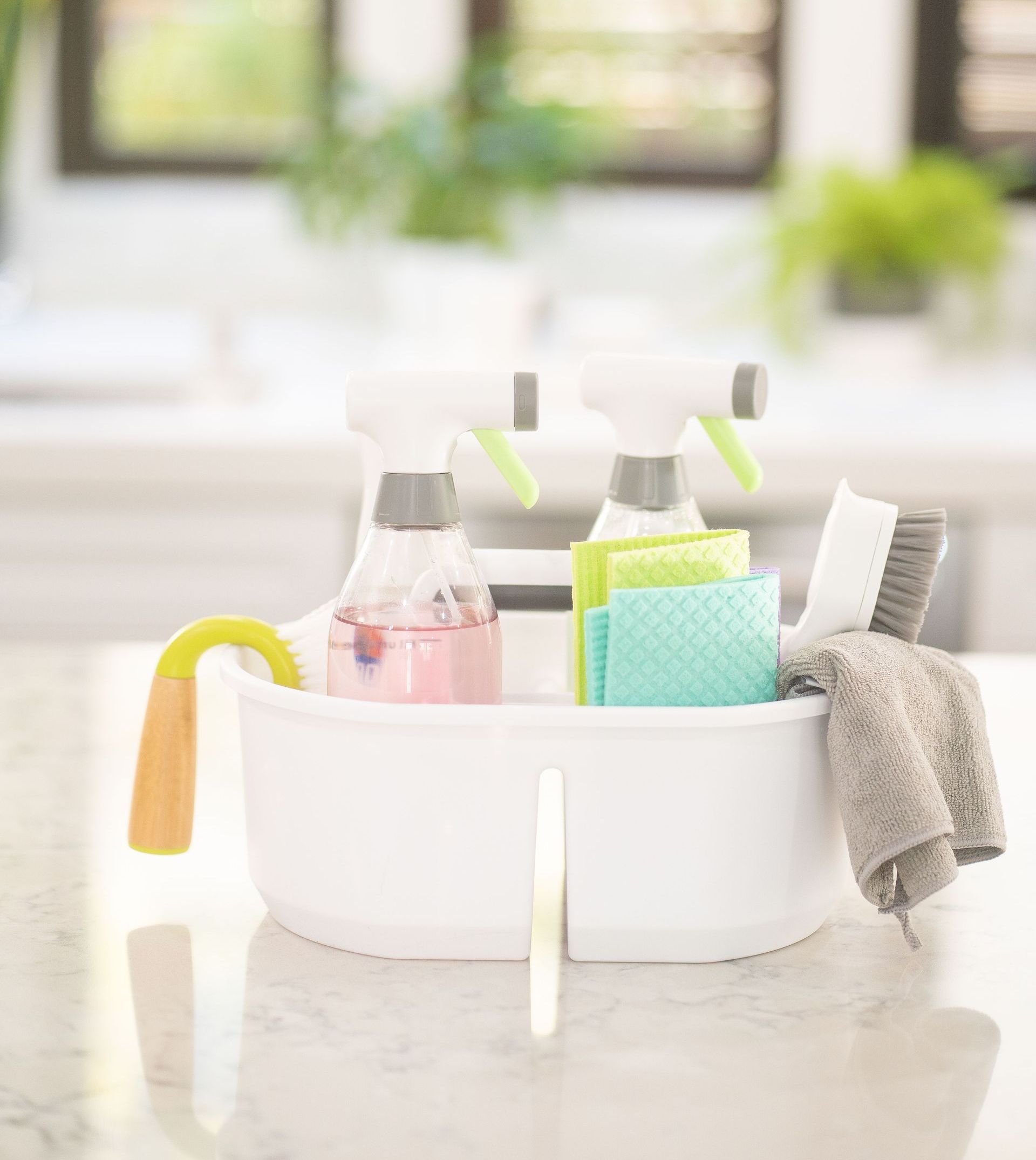 a white bowl filled with cleaning supplies is sitting on a counter .
