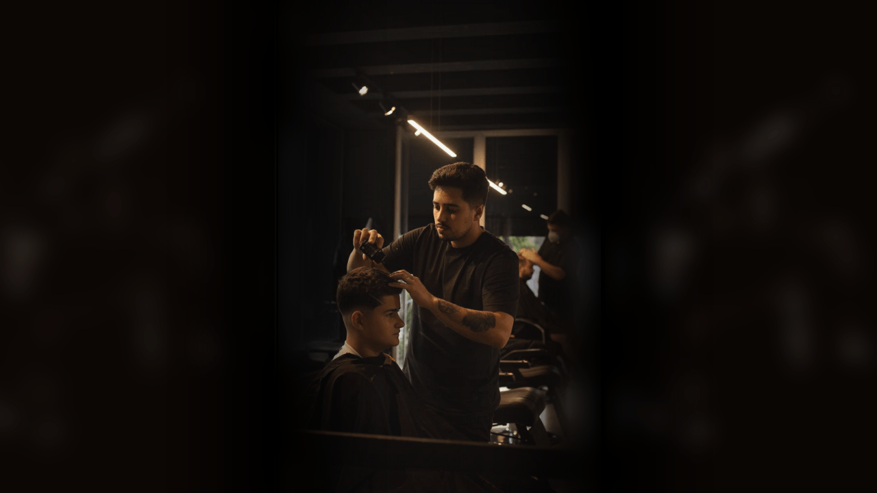Cabeleireiro fazendo corte masculino e barba.