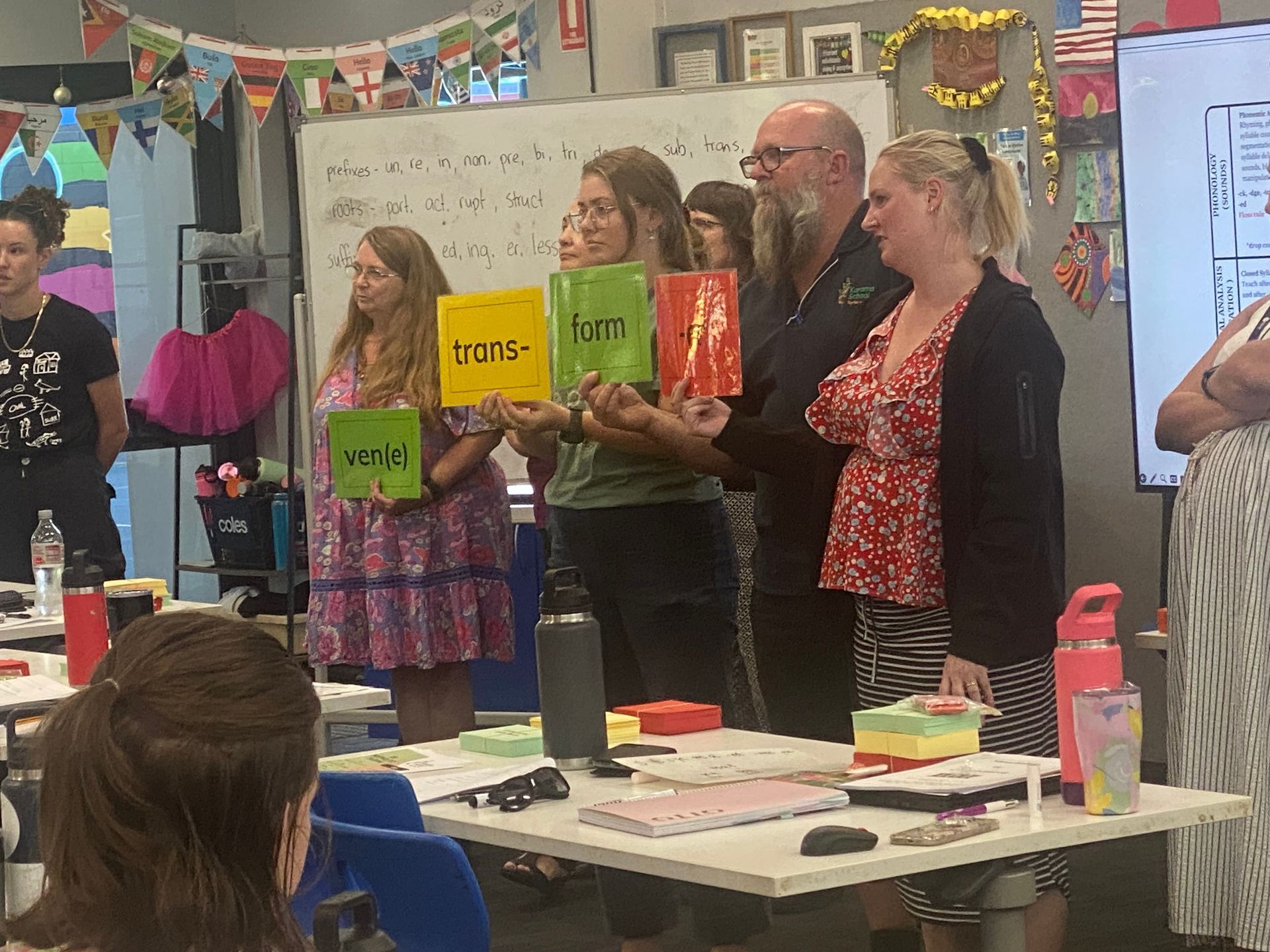Teachers holding colorful cards as they practice Morphology lessons for classroom application during Advanced Morphology training.