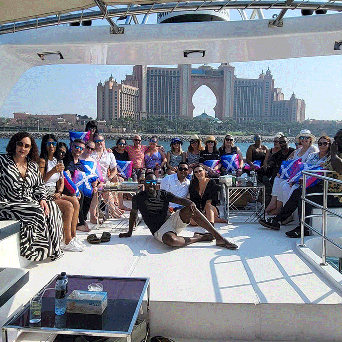 People on a yacht in Dubai with Atlantis Hotel in the background. Sunny day.