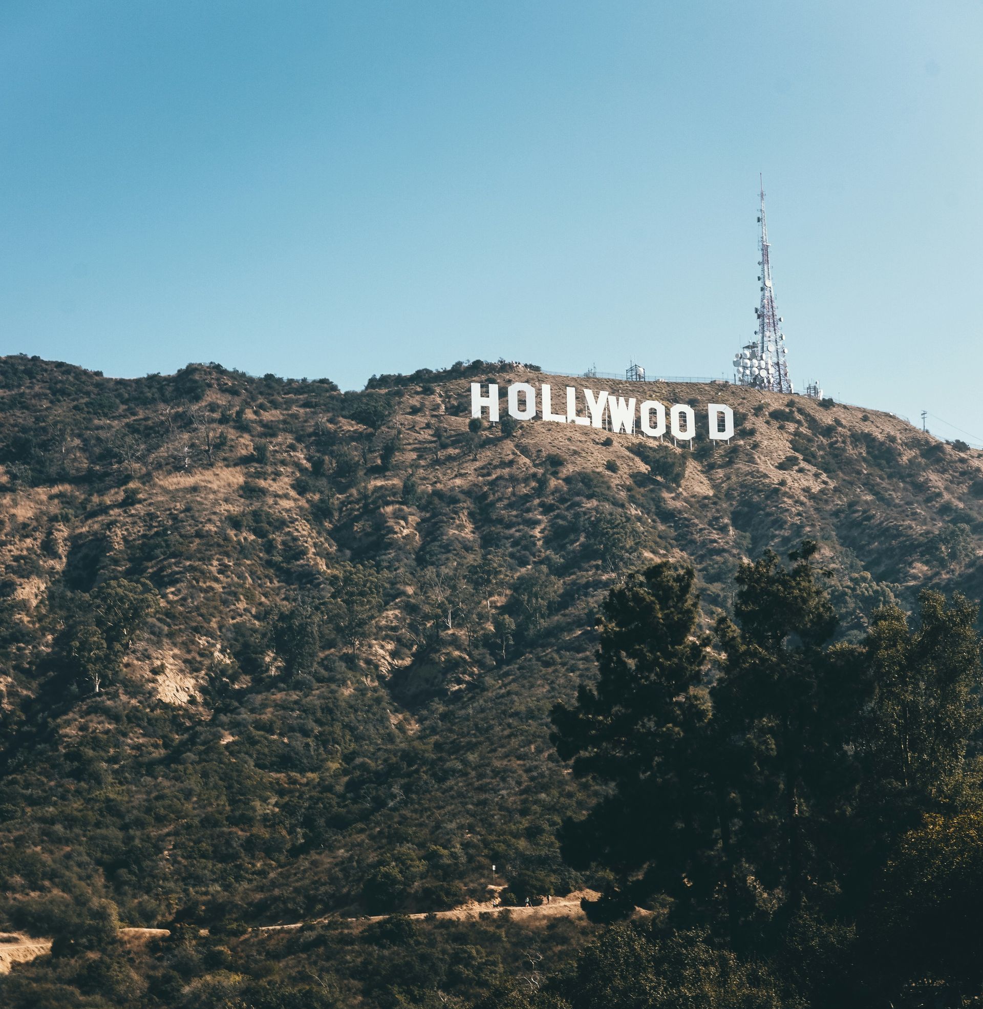 Hollywood sign on a brown hillside against a clear blue sky.