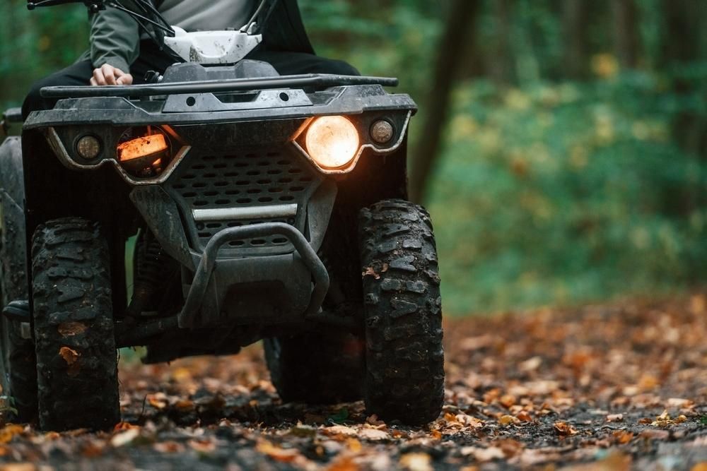 A Person Is Riding An Atv On A Dirt Road In The Woods — JBS Mobile In Richmond Hill, NSW