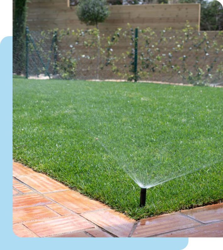 A sprinkler is spraying water on a lush green lawn.