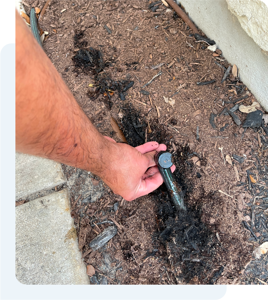 A person's hand doing system and calibration test on a water sprinkler system.