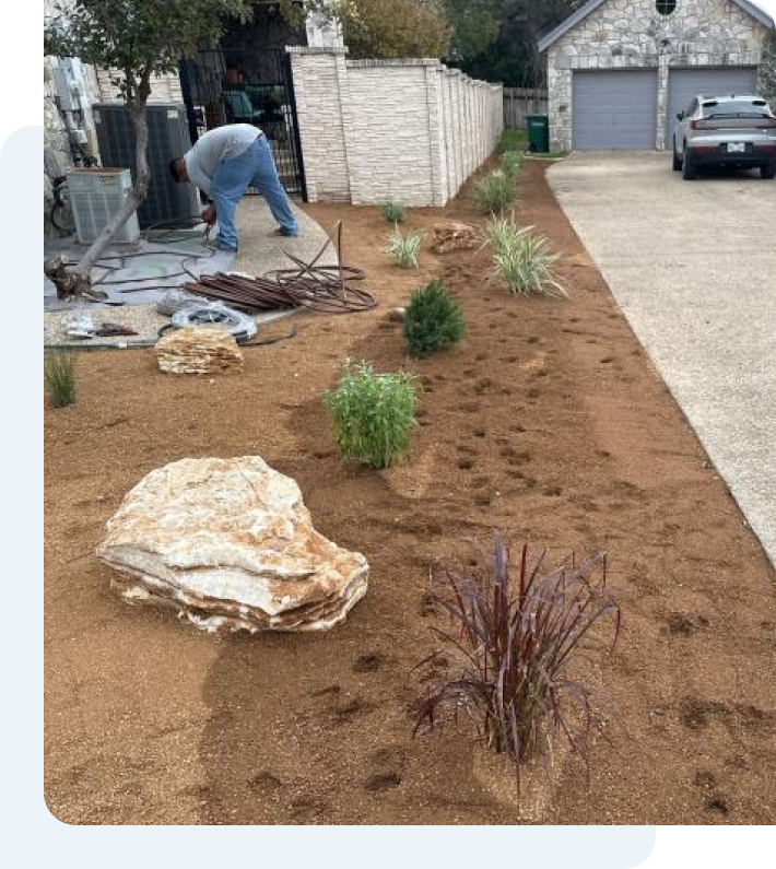 A man is working on a landscaping project in front of a house.