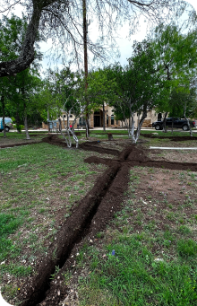 A yard with dug out lines for a new water sprinkler system installation.