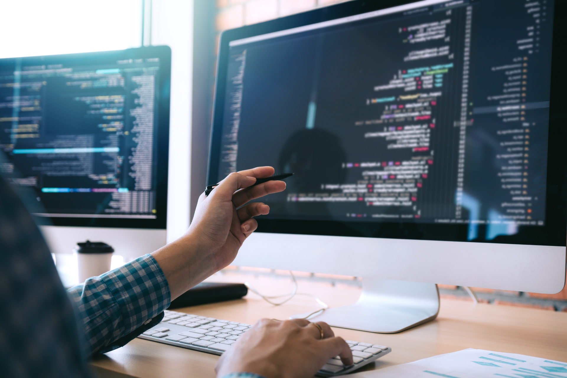 Un hombre está sentado en un escritorio trabajando en una computadora.
