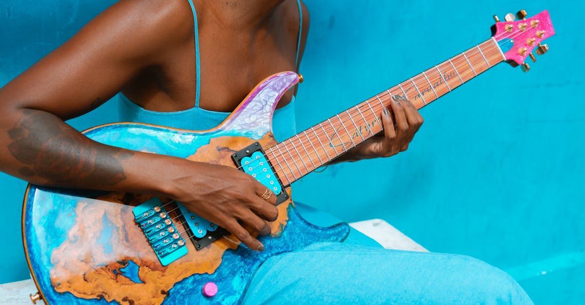 Uma mulher de vestido azul está tocando uma guitarra elétrica.